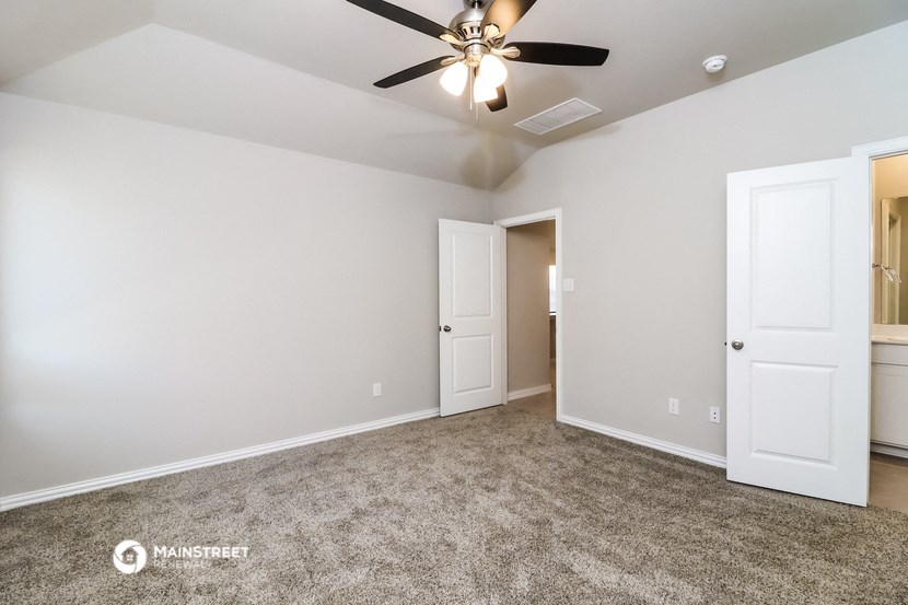 the spacious living room with ceiling fan and door to the closet