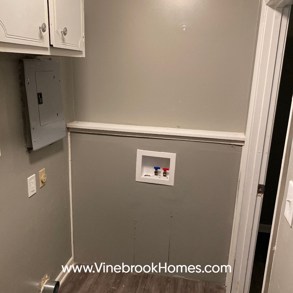 a wall with an electrical outlet and white cabinets
