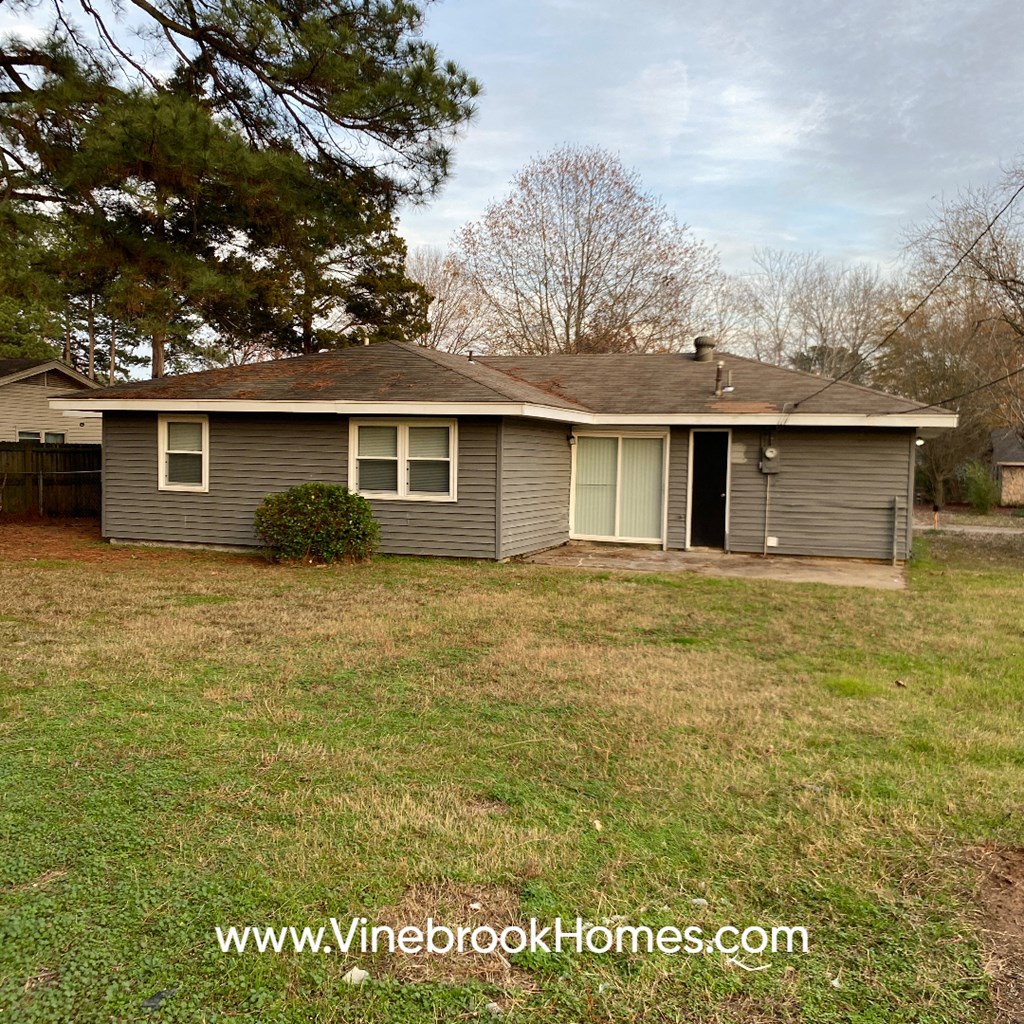 a small gray house with a yard in front of it