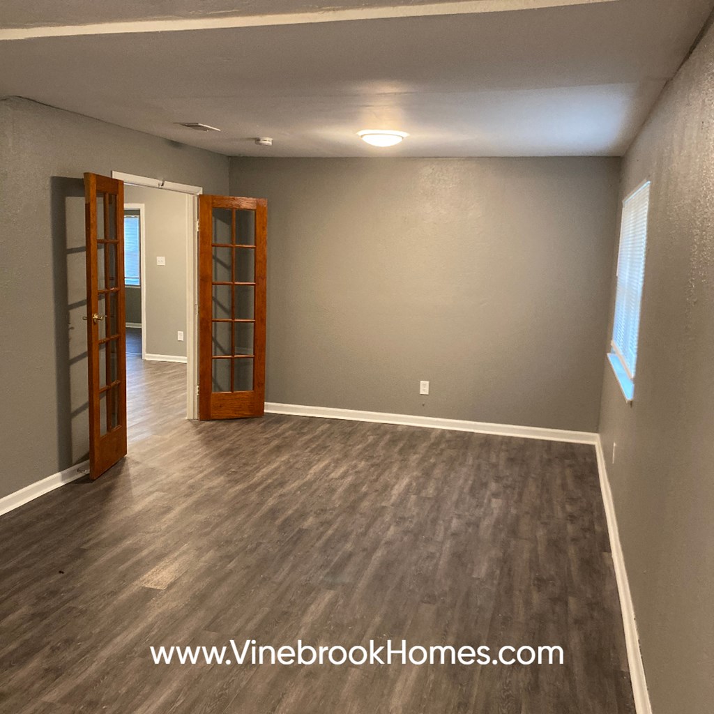 a empty living room with grey walls and wood floors