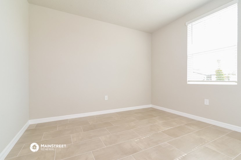 an empty room with a window and a tiled floor
