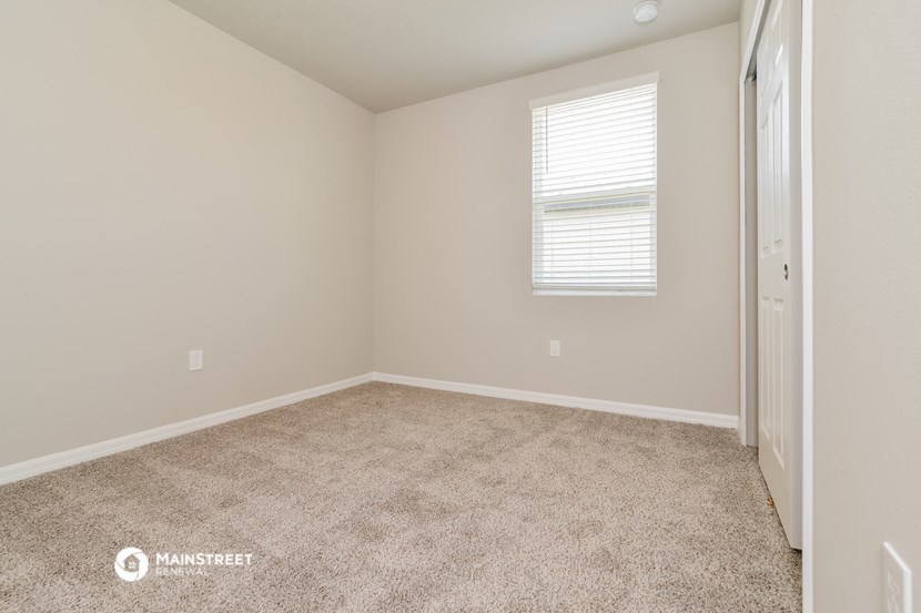 an empty room with carpet and a window