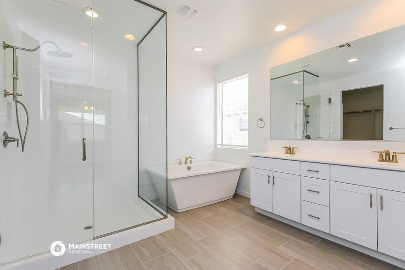 a white bathroom with a large shower and a tub and white cabinets