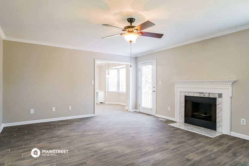 the living room with fireplace and ceiling fan