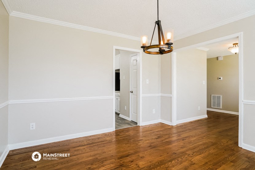 the living room and dining room with hardwood flooring and a chandelier