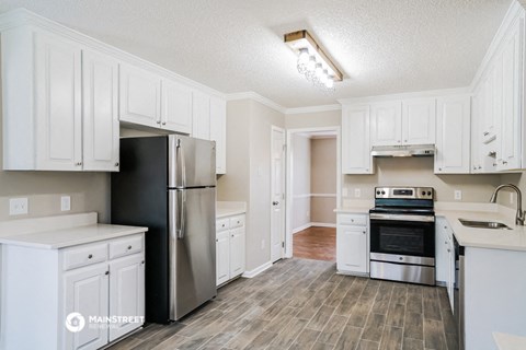 a kitchen with white cabinets and stainless steel appliances