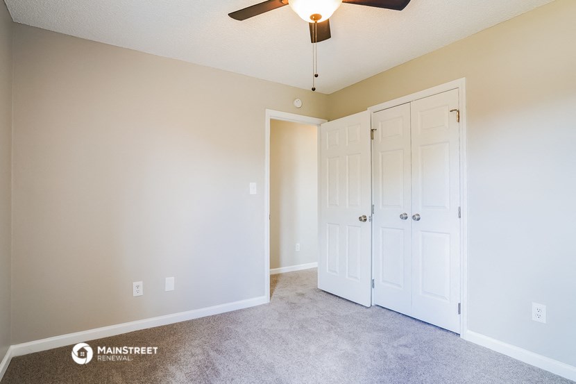 a bedroom with two closets and a ceiling fan