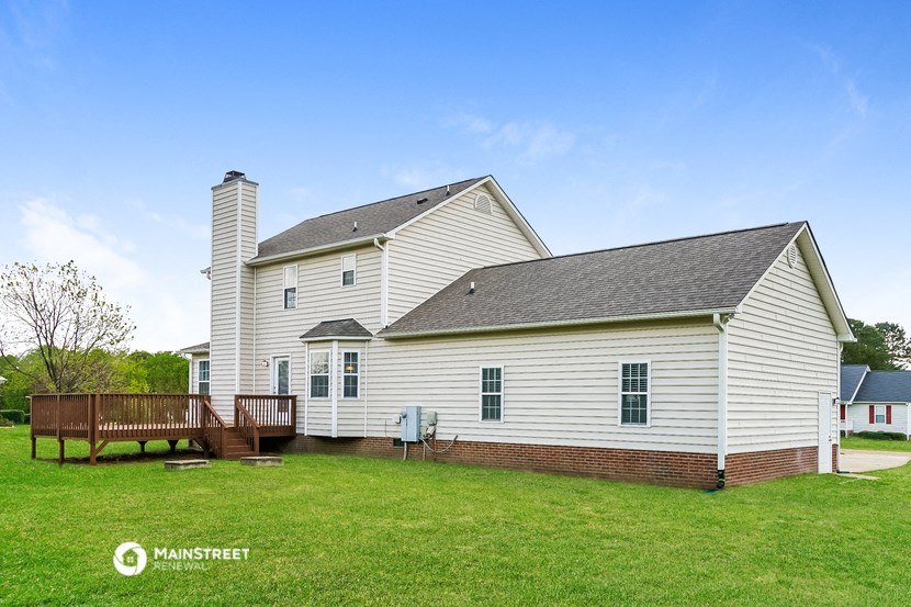 a white house with a deck and a wooden fence