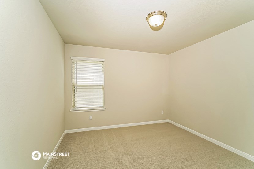 a spacious room with carpet and a window