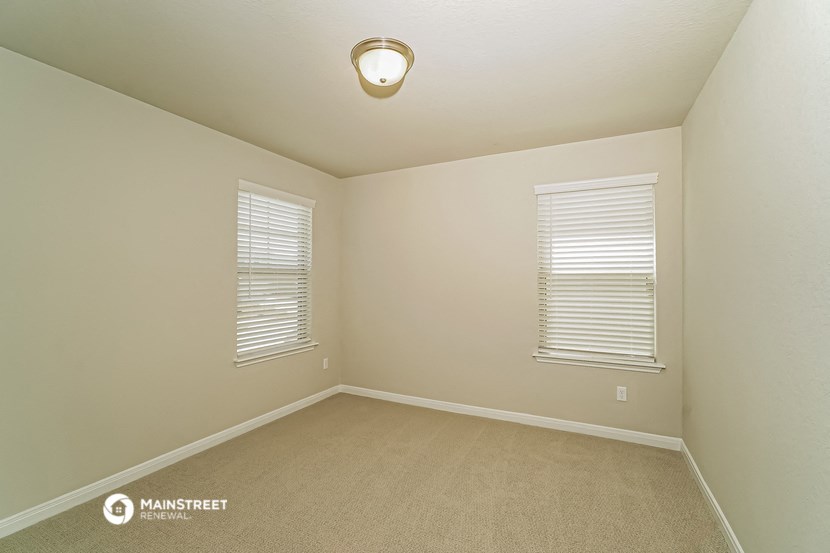 the upstairs bedroom has a carpeted floor and two windows