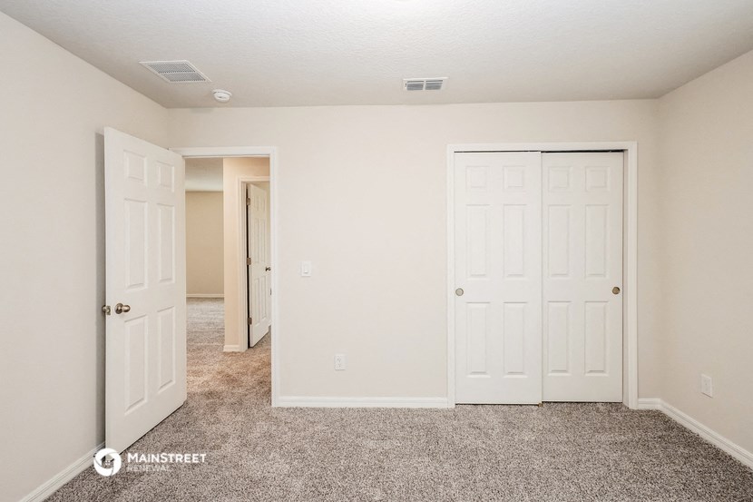 a bedroom with two closets and a door to a hallway