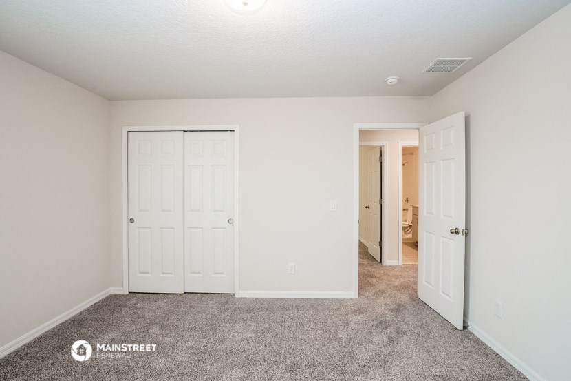 a bedroom with two closets and a door to a hallway