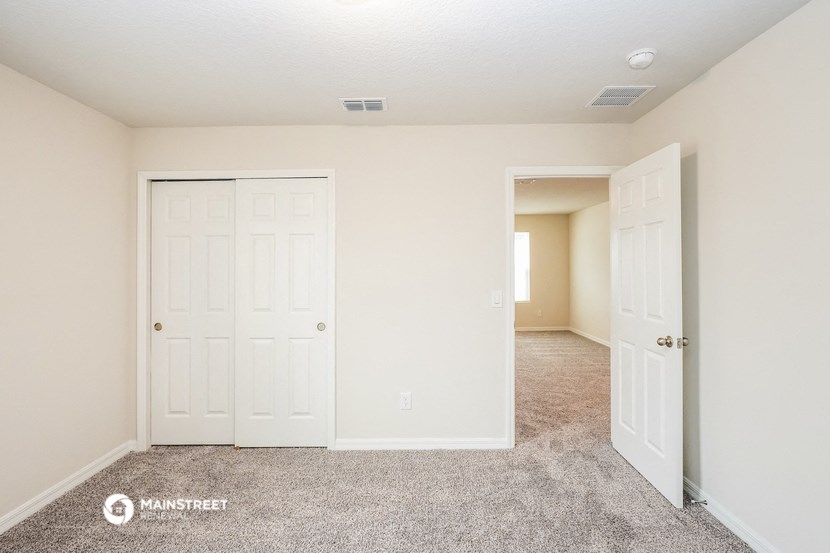 a bedroom with two closets and a door to a hallway