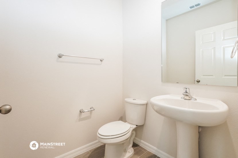 a white bathroom with a sink toilet and a mirror