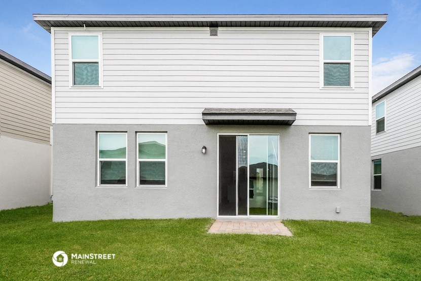 a white house with a glass door and a lawn