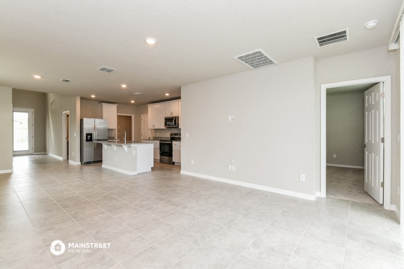 the spacious living room and kitchen with stainless steel appliances and tile flooring