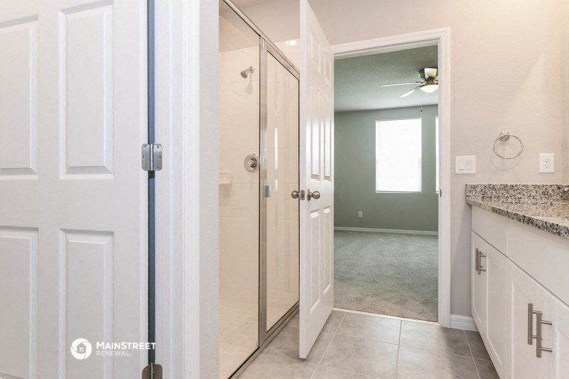 a bathroom with a shower and a door to a closet