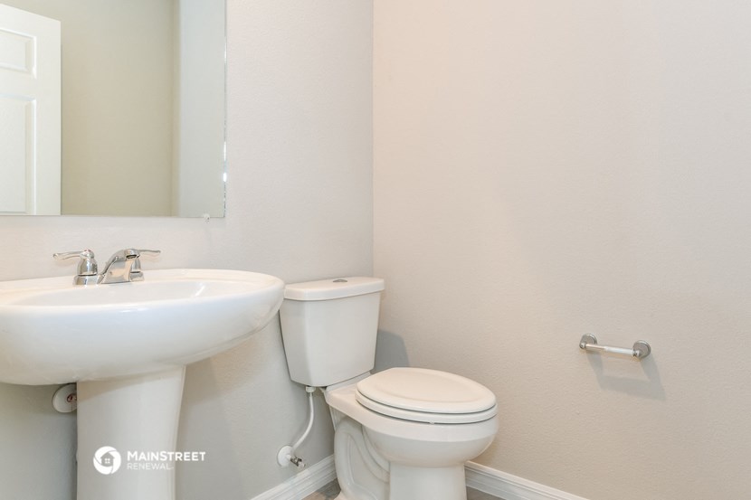 a bathroom with a toilet and a sink and a mirror