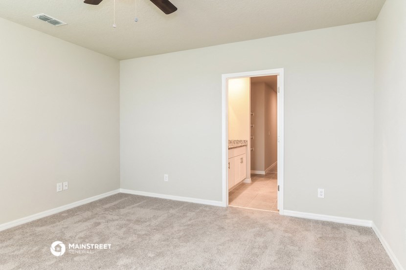 a living room with a carpeted floor and a doorway to a kitchen