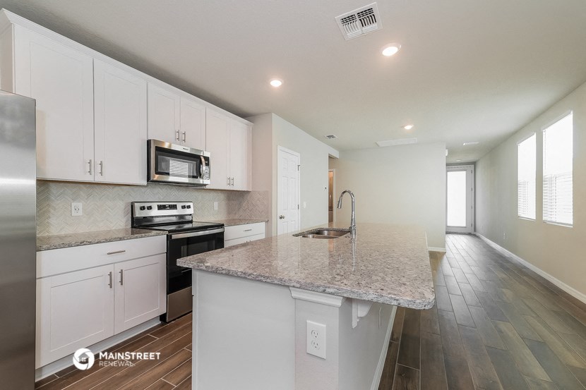 a kitchen with white cabinets and a granite counter top