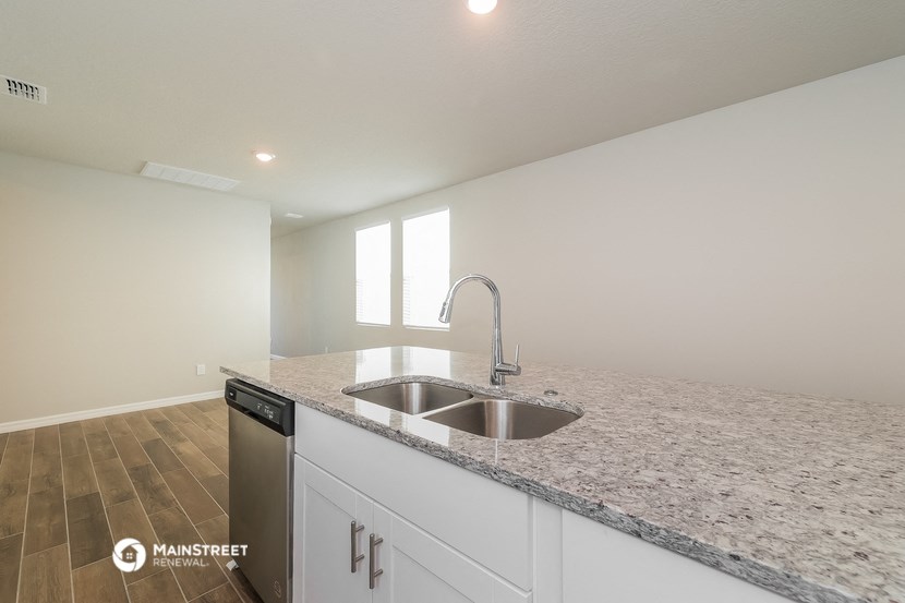 a kitchen with white cabinets and granite counter tops and a sink