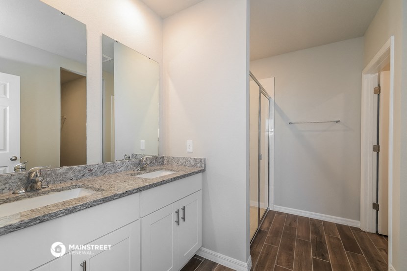 a bathroom with two sinks and a shower and a mirror