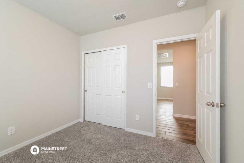 a bedroom with a closet and a door to a hallway