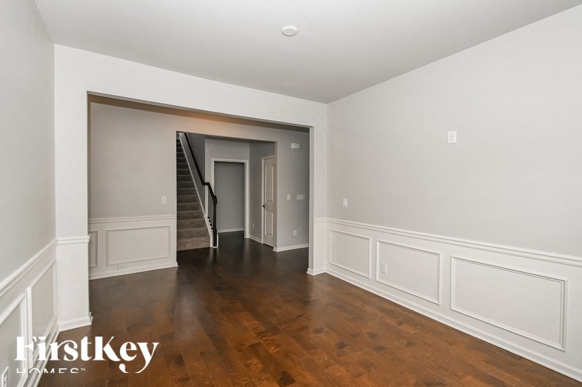 a renovated living room with white walls and wood floors