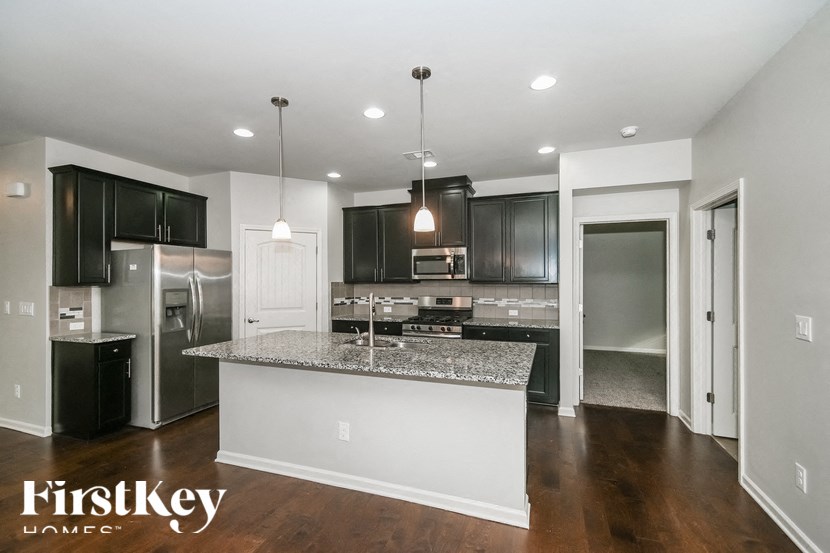 a kitchen with black cabinets and a granite counter top