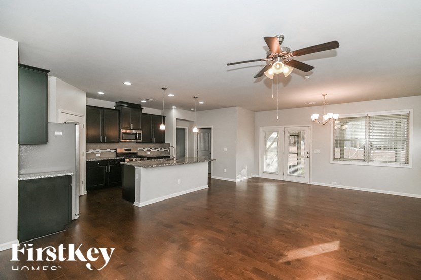 an open kitchen and living room with a ceiling fan
