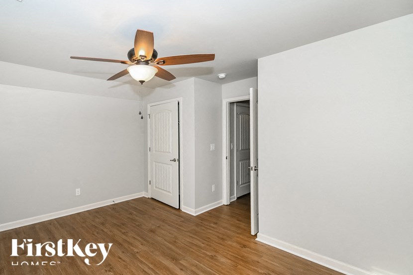 a bedroom with a ceiling fan and a door to a closet