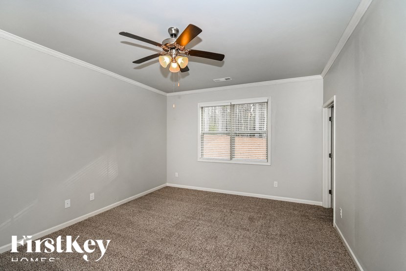 an empty room with a ceiling fan and a window