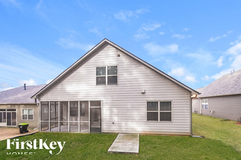 front view of a white house with glass doors and a lawn