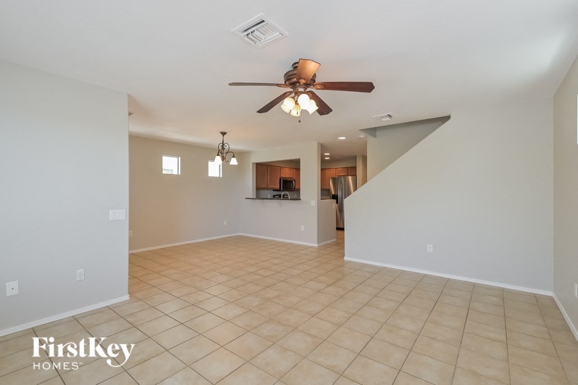 A spacious room with a ceiling fan and tiled flooring.