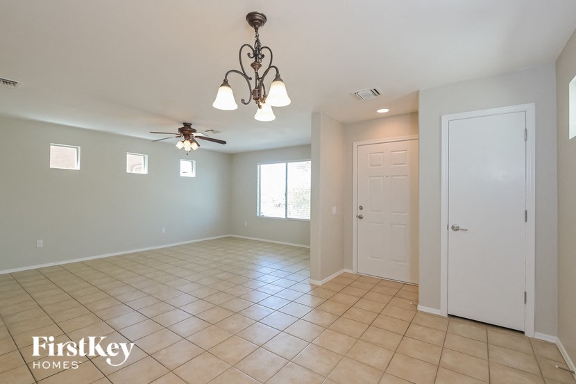A spacious room with a chandelier and a ceiling fan.