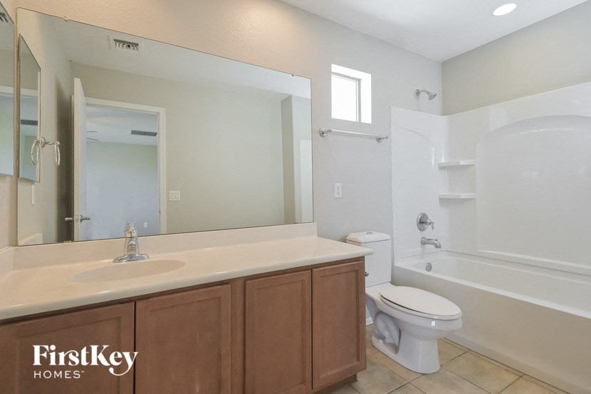 A bathroom with a white toilet and a white bathtub.