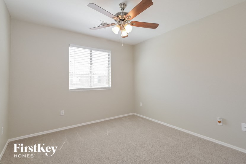 A room with a ceiling fan and a window.