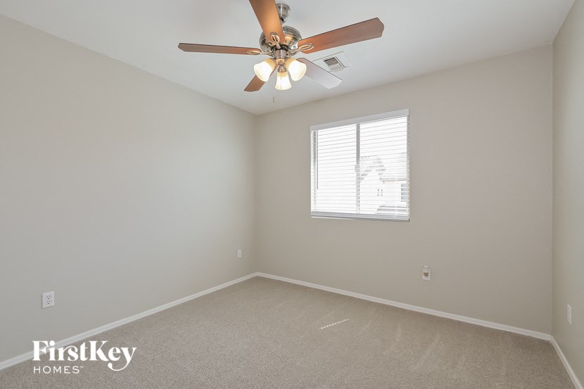 A room with a ceiling fan and a window.