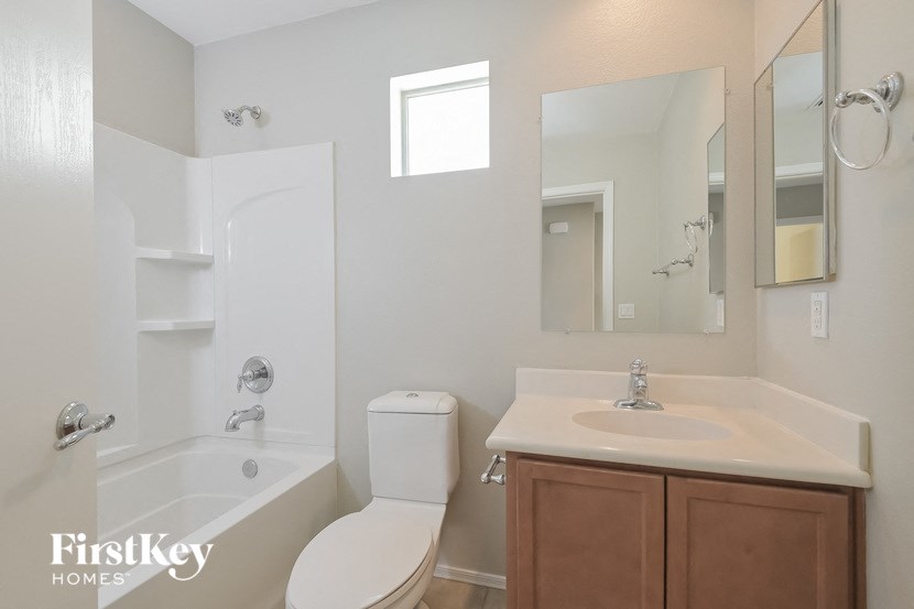 A white bathroom with a toilet, sink, and tub.