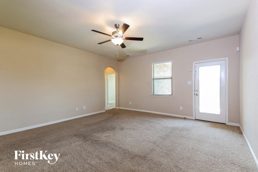 the living room of an empty house with a ceiling fan