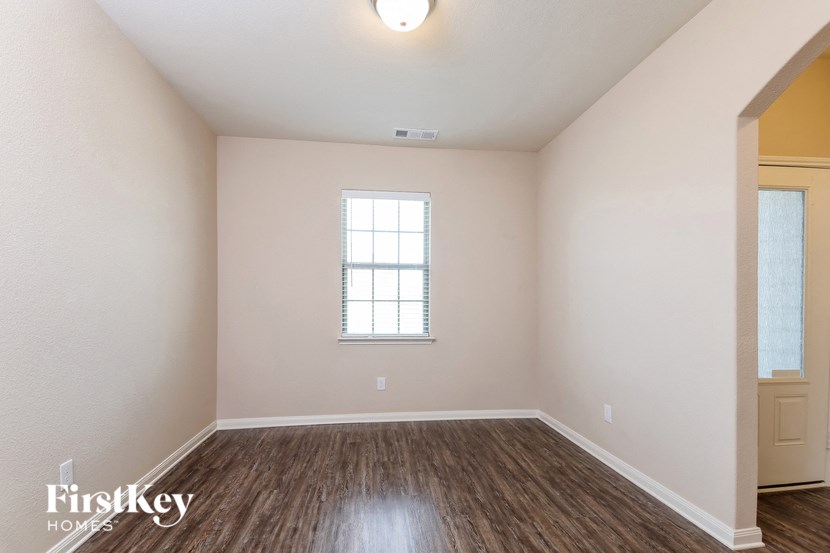 the spacious living room with hardwood flooring and a window