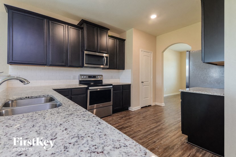 a kitchen with black cabinets and stainless steel appliances