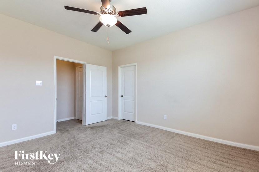 a living room with carpet and a ceiling fan