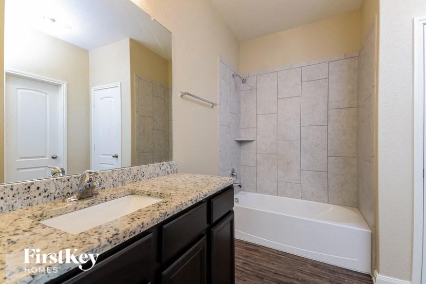 a bathroom with a sink and a tub and a shower