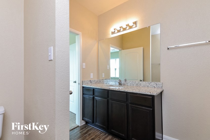 the master bathroom has a large vanity and a large mirror