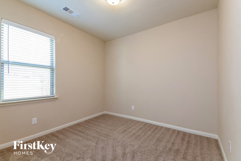 the bedroom of an attic with a window and carpet