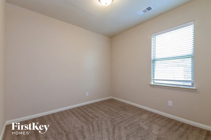 a bedroom with a carpeted floor and a window