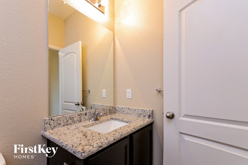 a bathroom with a sink and a mirror and a door