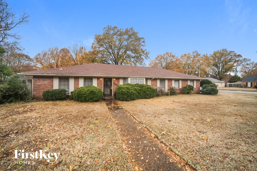 a brick house with a yard in front of it