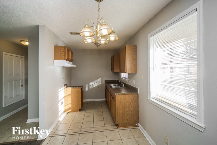 a kitchen with wooden cabinets and a large window